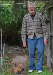  ?? ERIC BONZAR — THE MORNING JOURNAL ?? Morris Nibert, 87, of Lorain, stands next to a red fox. He says the animal has terrorized his neighborho­od for a month.
