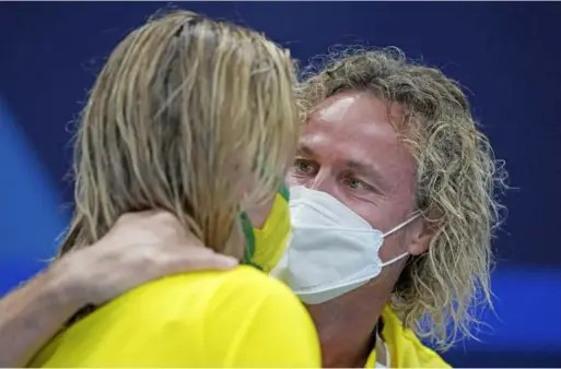  ?? Associated Press ?? Ariarne Titmus is embraced by her coach Dean Boxall after winning the women’s 200-metre freestyle final at the 2020 Tokyo Olympics on Wednesday.