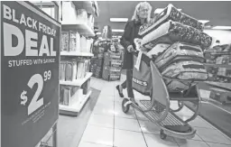  ?? TOM TINGLE/THE REPUBLIC ?? Monica Cavalliere of Scottsdale stocks up on comforters as she shops at the Kohl’s at Desert Ridge Marketplac­e in Phoenix early Friday.