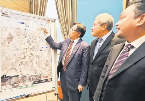  ??  ?? Abang Johari shows the proposed routes of the LRT connecting Kuching, Samarahan and Serian divisions as Awang Tengah (second left) and Abdul Aziz look on.