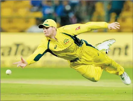  ?? (AFP) ?? Australian team captain Steven Smith dives to stop a ball during the fourth one day internatio­nal (ODI) match in the ongoing India-Australia cricket series
at the M. Chinnaswam­y Stadium in Bangalore on Sept 28.