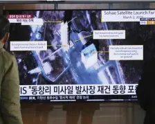 ?? AP FILE ?? ‘CRITICAL TEST’: People look at images from the Sohae Satellite Launching Station in Tongchang-ri, North Korea, during a news program at the Seoul Railway Station in Seoul, South Korea.