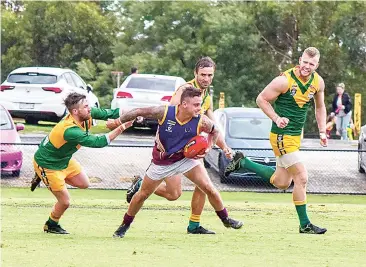  ??  ?? Displaying his great football talent in March last year Tyson Bale is outnumbere­d by Garfield players but he manages to break free.