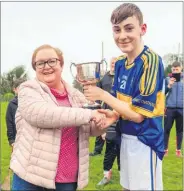  ?? ?? Phil O’Brien presenting John Crowley with the winning cup following Carrigtwoh­ill’s success in the U14 hurling tournament final for the Albert Griffen Cup played recently in Ballynoe.