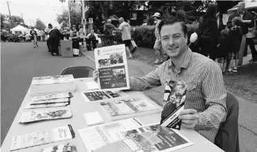  ?? RICK MACWILLIAM, EDMONTON JOURNAL ?? Jarrett Campbell, 25, president of the Oliver Community League, mans a table at the community’s festival Saturday, distributi­ng informatio­n about league activities and programs.