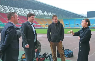  ?? YANG JUN / FOR CHINA DAILY ?? Wen Xiaoting, chairwoman of the soccer club Guizhou Hengfeng Zhicheng, explains her brand promotion idea during chat with three German Channel 2 television staff in a soccer stadium in Guizhou province.