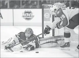  ?? Mark J. Terrill Associated Press ?? KINGS GOALTENDER Jonathan Quick stretches toward the puck as Oliver Bjorkstran­d of the Columbus Blue Jackets attempts to poke it into the net.