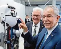  ??  ?? Bundespräs­ident Alexander Van der Bellen, Ministerpr­äsident Winfried Kretschman­n und ein Roboter APA