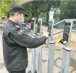  ?? ?? A security guard tests the “digital sentinels” at Binjiang Forest Park in Shanghai’s Pudong New Area. — Ti Gong