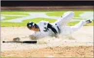  ?? Kathy Willens / Associated Press ?? The Yankees’ Gleyber Torres slides home to score on an infield single by Aaron Hicks in the eight inning against the Astros on Thursday in New York.