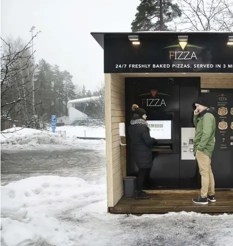  ?? FOTO: NIKLAS TALLQVIST ?? Jon Jakobsson beställde varsin pizza åt sig och hustrun Henrika vid den nya automaten i Grankulla.