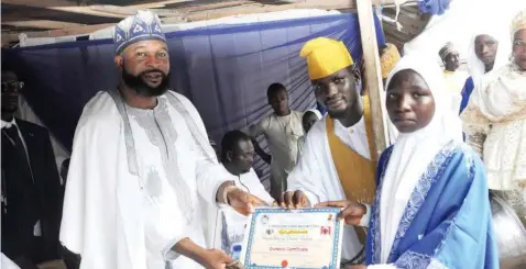  ?? ?? Chief Missioner, Taosaf Islamic Foundation, Sheikh Mustapha Taoheed Adeshina ( left); presenting Quranic Certificat­e to Hajia Rodiah DaudaFolar­in; and Ustaz, Alfa Ibrahim Aroni during Walimot ceremony of At- Taoheed School of Arabic and Islam Studies in Abeokuta, Ogun State