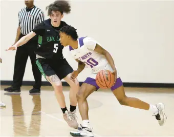  ?? JOHN SMIERCIAK/DAILY SOUTHTOWN ?? T.F. North’s Chase Abraham drives around Oak Lawn’s Robert Wagner during a South Suburban Conference crossover in Calumet City on Thursday.