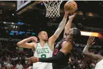  ?? MARTA LAVANDIER/AP ?? Celtics center Kristaps Porzingis blocks a shot by Heat center Bam Adebayo during the second half on Thursday, in Miami. The Celtics defeated the Heat 143-110.