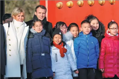  ?? CHARLES PLATIAU / REUTERS ?? President Emmanuel Macron of France and his wife, Brigitte Macron, pose with Chinese and French schoolchil­dren during a visit to the Palace Museum, known as the Forbidden City in the West, in Beijing on Tuesday.