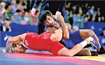  ?? AP PHOTO ?? India’s B Bajrang (in blue), a strong contender for the gold, lasted just 84 seconds in his 61kg freestyle final bout against Canada’s David Tremblay.