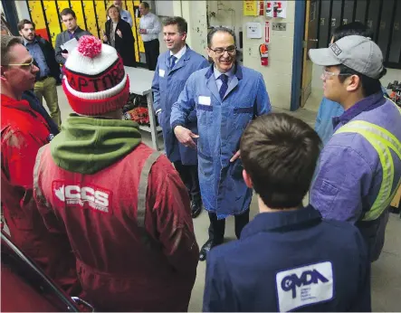  ?? RYAN MCLEOD ?? Alberta Minister of Finance Joe Ceci chats with auto shop students after he announced $24 million in funding to pay for upgrades at Forest Lawn High School over the next four years. Ceci’s budget allocates $500 million for 26 new schools across the...