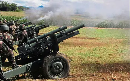  ??  ?? All clear: Philippine troops firing their 105mm howitzer cannons towards enemy positions from their base near Butig town in Lanao del Sur province. — AFP