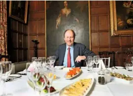  ??  ?? Sir Richard FitzHerber­t prepares to host a tea in the panelled library of Tissington Hall. It boasts a collection of more than 3,000 books.