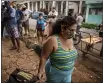  ?? RAMON ESPINOSA — THE ASSOCIATED PRESS ?? Yuliet Colon pulls her rolling grocery cart as she walks home after a visit to the agro market in Havana, Cuba on April 2.