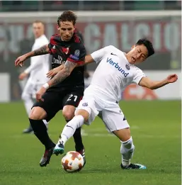  ??  ?? AC Milan’s Lucas Biglia ( left) and Vienna’s Jinhyun Lee vie for the ball in their Europa League Group D match at the San Siro Stadium in Milan on Thursday. The hosts won 4- 0. —