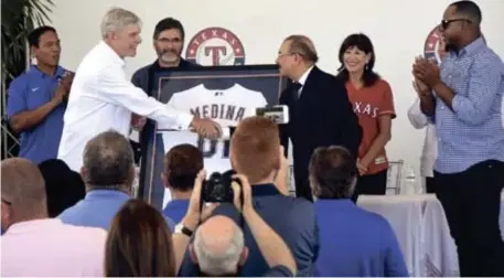  ??  ?? Ray Davis, propietari­o de los Rangers de Texas, entrega una camiseta al presidente Danilo Medina.