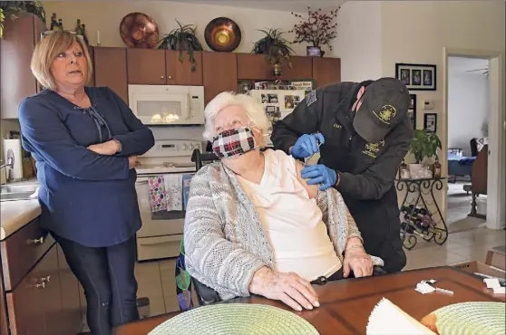  ?? Photos by Lori Van Buren / Times Union ?? EMT and Paramedic James Mudge gives Mary Nardiello the vaccine in her Albany home. Her daughter Pat Mangini, left, says she is relieved.