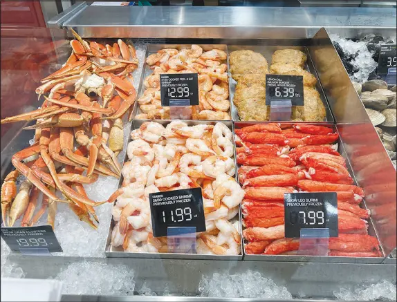  ?? WILFREDO LEE / AP ?? Fresh seafood prices are shown at a grocery store earlier this year in Surfside, Fla. The economy shrank in the first half of this year, underscori­ng fears of a broad-based slowdown that could lead to a recession. At the same time, the number of people seeking unemployme­nt benefits fell to a fivemonth low. Inf lation, meantime, remains near its highest level in four decades, though gas costs and other prices have eased in recent weeks.