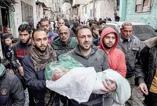  ?? AFP PHOTO ?? DEAD DAUGHTER
A man carries the body of his daughter, who was killed during an Israeli bombing, in a funeral procession in the city of Rafah, southern Gaza Strip, on Wednesday, Jan. 17, 2024.