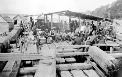  ??  ?? Loggers relax at a cookhouse on a timber raft.