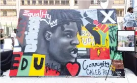  ??  ?? LEFT: A mural dedicated to 17-year-old activist Caleb Reed, who was fatally shot last August, stands Saturday in Daley Plaza.