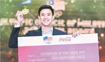  ??  ?? National swimmer Welson Sim with his Olympian of the Year 2017 award. — Bernama photo