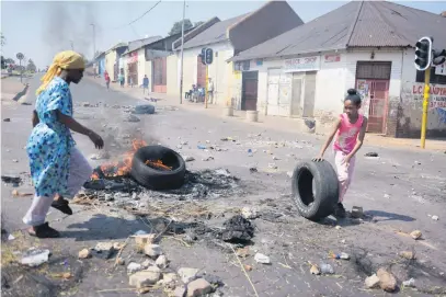  ?? Pictures: Tracy Lee Stark ?? ALL HANDS ON DECK. Residents, including children as young as four, block roads into Westbury yesterday after a bystander was killed by a stray bullet during a gang shootout on Thursday.