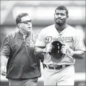  ??  ?? YASIEL PUIG of the Dodgers leaves the field in the ninth inning after straining his right hamstring.