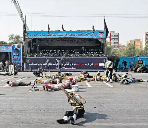  ??  ?? Injured soldiers lie on the ground after the gunmen opened fire on the military event