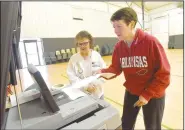  ?? NWA Democrat-Gazette/FLIP PUTTHOFF ?? Louisa Terrick (left), poll worker, helps Leigh Freeze cast her ballot Tuesday during the sales tax election to pay for a new courthouse and upgrade the current courthouse. Freeze voted at Bentonvill­e Church of Christ.