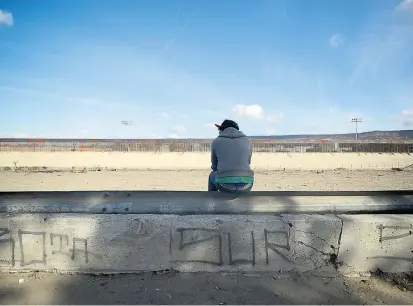  ??  ?? Ein Migrant blickt auf den Zaun an der US-mexikanisc­hen Grenze. Die Uno will für Ordnung sorgen.