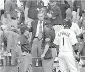  ?? JOHN ZICH/AFP ?? Baseball Commission­er Bud Selig, center, talks to umpires Jerry Davis, right, and Tim Tschida about calling the game in the 11th inning as Luis Castillo of the Florida Marlins stands on deck.