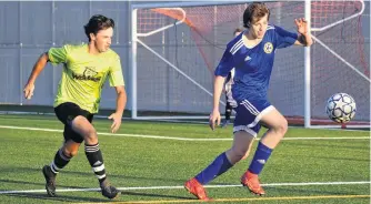  ?? JEREMY FRASER • CAPE BRETON POST ?? Hayden Desorisers of the New Waterford Wolves, left, chases down Ryan MacDonald of Whitney Pier during Cape Breton and District Soccer League boys under-18 semifinal action at MacKinnon Memorial Field in New Waterford on Monday. The Wolves won the game and will play in the Cape Breton Cup final Saturday in Sydney.