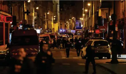  ?? F. Guillot / AFP ?? Des dizaines de policiers et de pompiers devant le Bataclan, dans le 11e arrondisse­ment de Paris, dans la nuit du 13 au 14 novembre 2015.