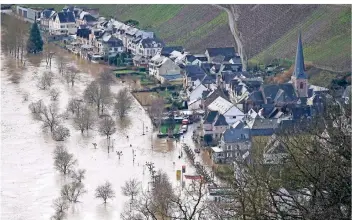  ?? FOTO: HARALD TITTEL/ DPA ?? Die Mosel hat die B53 in Ürzig überschwem­mt. Viele Straßen sind entlang des Flusses abschnitts­weise überflutet und für den Verkehr gesperrt.