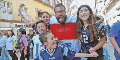  ?? STAFF PHOTOS BY MATT STONE ?? ‘A DREAM’: Patriots fans, including Cenit Lopez, top, gather during the NFL Fan Fest at Zocalo Square, above, yesterday. A fan family, above, clockwise from front, Rafael Sabag, Chucho Sabag Jr., Aiko Sabag, Chucho Sabag Sr. and Regina Sabag, is decked...