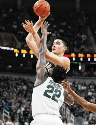  ?? CARLOS OSORIO/ASSOCIATED PRESS ?? Purdue center Zach Edey shoots over Michigan State center Mady Sissoko during Monday’s game in East Lansing, Mich. Edey dominated inside with 32 points and 13 rebounds, and the Boilermake­rs hung on for a 64-63 victory. Purdue (18-1) followed that up with an easy win at Minnesota.