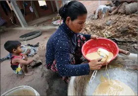  ?? ?? Ith checks the consistenc­y of palm sugar being made from the sap of palm.