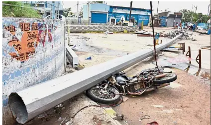  ??  ?? Powerful storm: A fallen pole and a damaged motorbike are seen on a road after Gaja hit Velankanni in Nagapattin­am district in Tamil Nadu, India. — Reuters