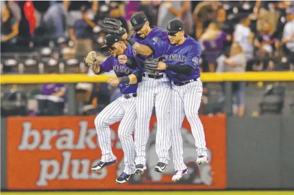  ??  ?? Rockies outfielder­s, from left, Gerardo Parra, Ian Desmond and Carlos Gonzalez celebrate after a 6-1 victory over the Padres at Coors Field on Friday night.
