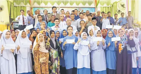  ??  ?? Mahdzir (third row, centre) in a group photo with recipients after handing over scholarshi­p to children of rubber smallholde­rs and Risda, at SM Kuala Nerang. — Bernama photo