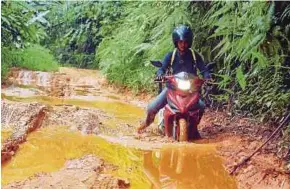  ?? NAZIRUL ROSELAN
PIC BY ?? Ahmad Saidin Mohd Idris has to ply muddy, pothole-ridden roads to reach SK Lenjang everyday to teach Orang Asli children.