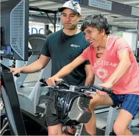  ??  ?? Sponsored student Ihaia, using the virtual reality bike with trainer Ace.