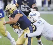  ?? NICK WASS/ASSOCIATED PRESS ?? Navy quarterbac­k Xavier Arline tries to break a tackle against Tulsa on Saturday.